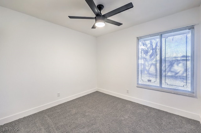 empty room with ceiling fan, dark colored carpet, and baseboards