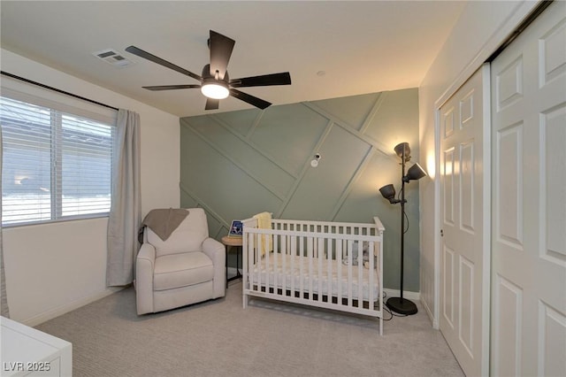 bedroom featuring baseboards, visible vents, a crib, and carpet flooring