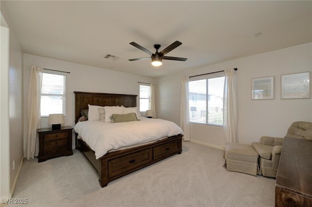 bedroom with a ceiling fan, visible vents, light carpet, and baseboards