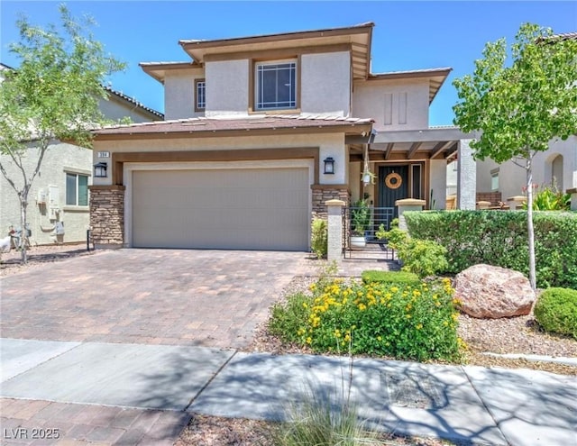 view of front of home featuring decorative driveway, stone siding, an attached garage, and stucco siding