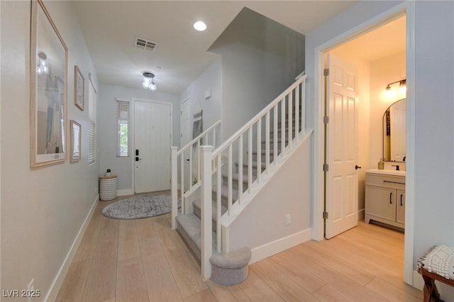 entrance foyer with recessed lighting, visible vents, baseboards, light wood-style floors, and stairway