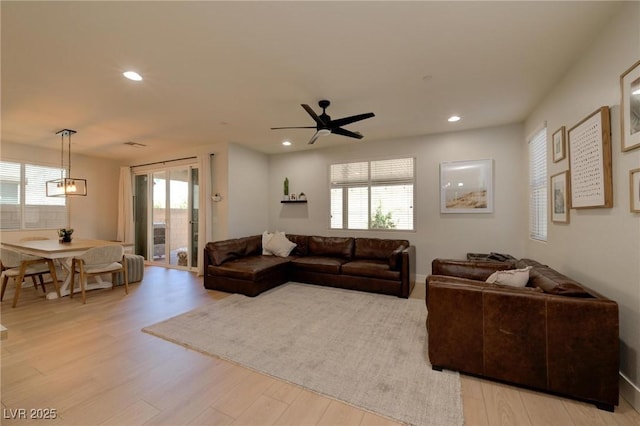 living area featuring ceiling fan, recessed lighting, light wood-type flooring, and a healthy amount of sunlight