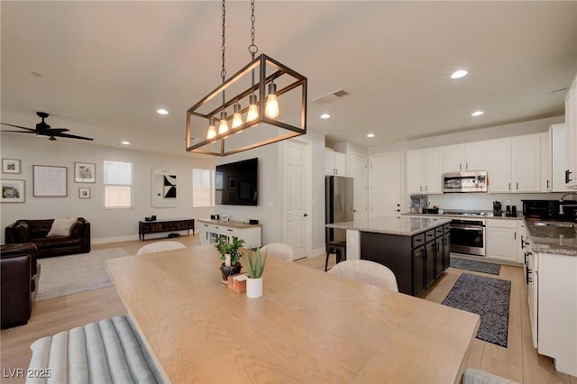 dining space with ceiling fan, light wood-style flooring, recessed lighting, visible vents, and baseboards