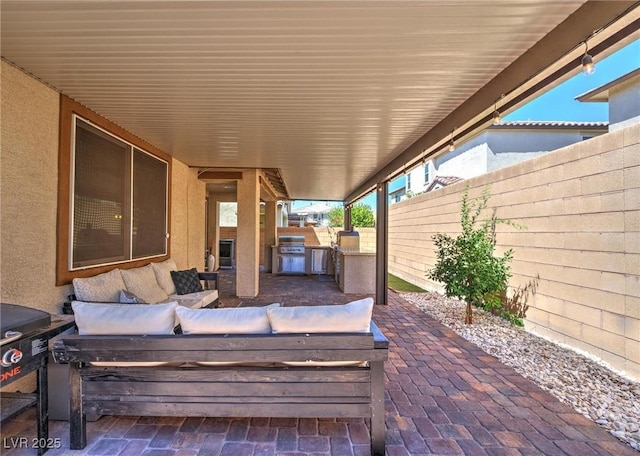 view of patio featuring exterior kitchen, area for grilling, and a fenced backyard