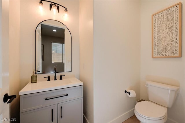 bathroom featuring vanity, toilet, and baseboards