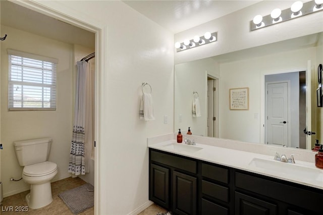 bathroom with double vanity, a sink, toilet, and tile patterned floors