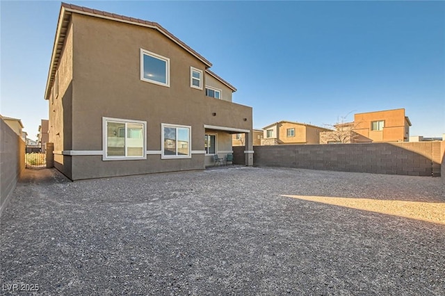 back of house with a patio area, a fenced backyard, and stucco siding