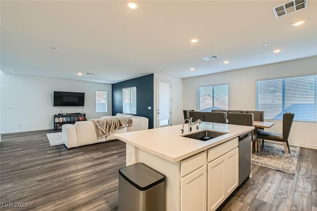 kitchen featuring visible vents, a sink, an island with sink, and dishwasher