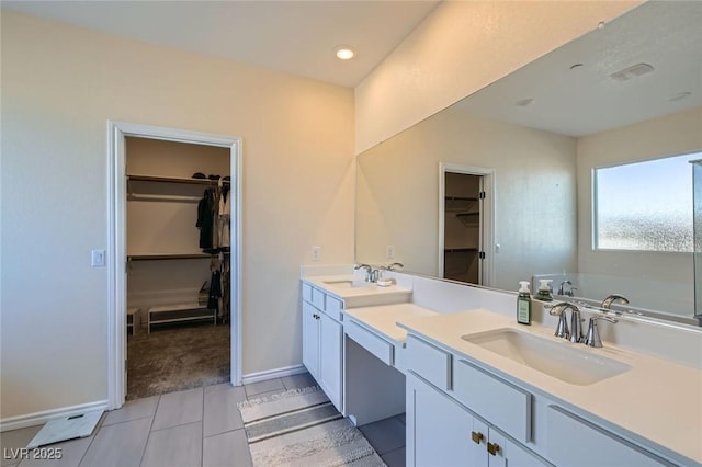 full bathroom with a walk in closet, tile patterned flooring, a sink, and double vanity