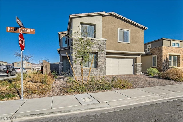 view of front of home featuring a garage, stone siding, decorative driveway, and stucco siding