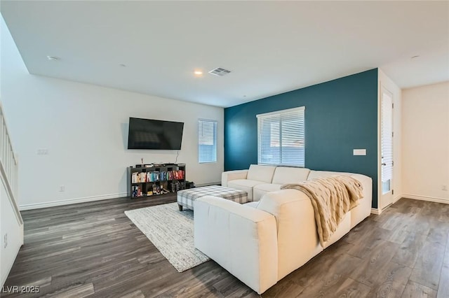 living area featuring baseboards, visible vents, and dark wood finished floors