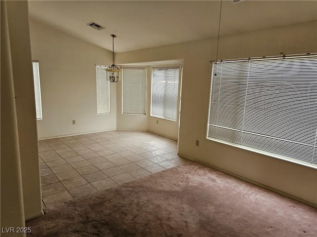 empty room with carpet, visible vents, vaulted ceiling, a chandelier, and tile patterned floors