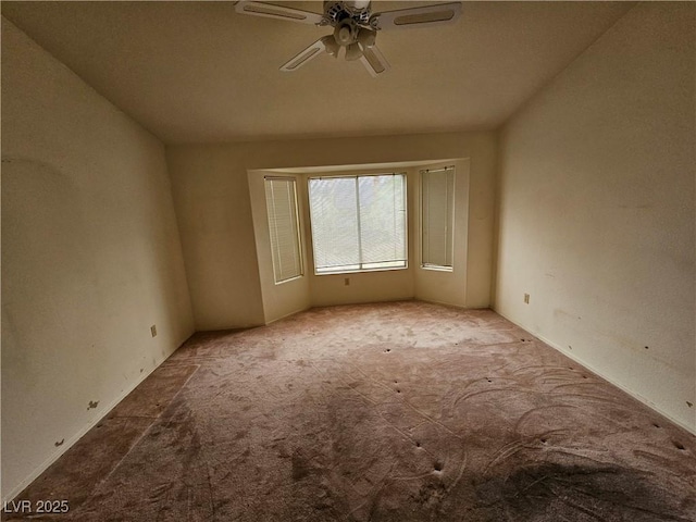 unfurnished room with carpet floors and a ceiling fan