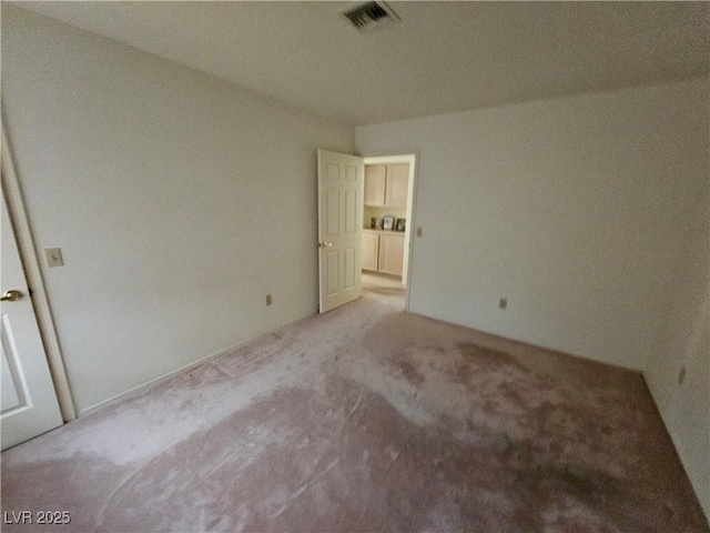 unfurnished bedroom featuring light colored carpet and visible vents