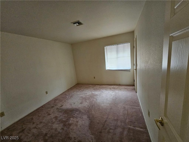 carpeted empty room featuring visible vents