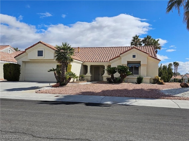 mediterranean / spanish house featuring a garage, a tile roof, driveway, and stucco siding