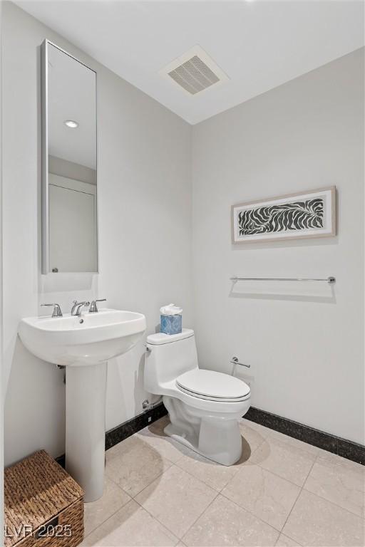 bathroom featuring toilet, baseboards, and visible vents