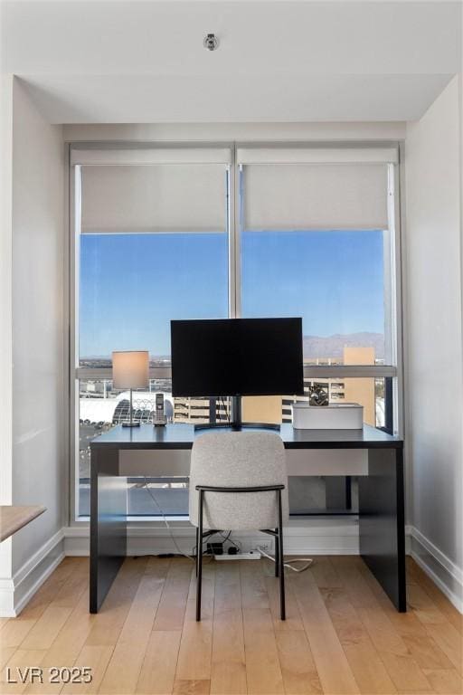 office space with light wood-style floors and baseboards