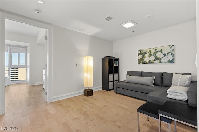 living area with light wood finished floors, baseboards, and visible vents