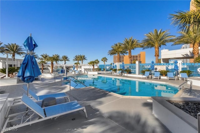 community pool with a patio and fence