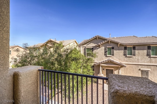 4542 Townwall St, Las Vegas, NV 89115 - view of front of property with a tiled roof, a balcony, and stucco siding