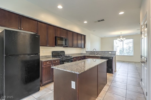 4542 Townwall St, Las Vegas, NV 89115 - kitchen with light tile patterned floors, a sink, a center island, light stone countertops, and black appliances