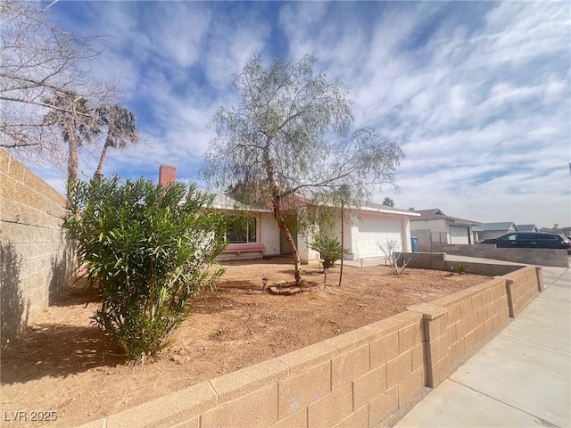 view of front of house featuring an attached garage, driveway, and fence