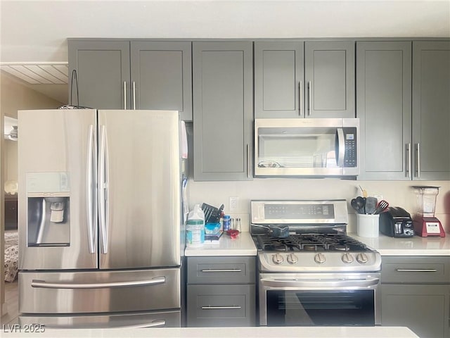 kitchen featuring light countertops, appliances with stainless steel finishes, and gray cabinetry