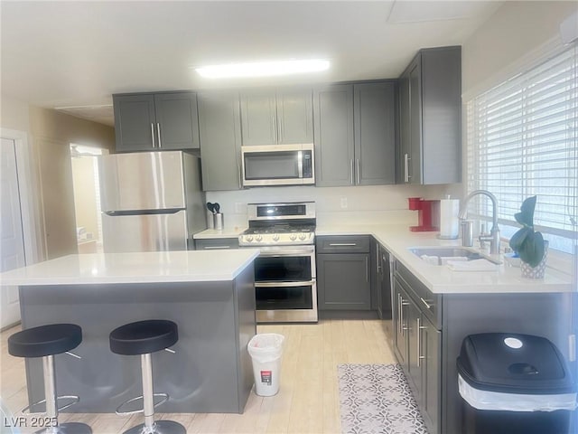 4194 Greenpoint St, Las Vegas, NV 89147 - kitchen with appliances with stainless steel finishes, gray cabinets, a breakfast bar area, and light countertops
