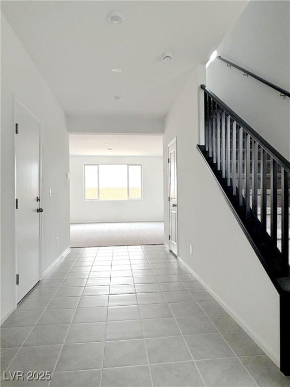 interior space with baseboards, stairway, and tile patterned floors