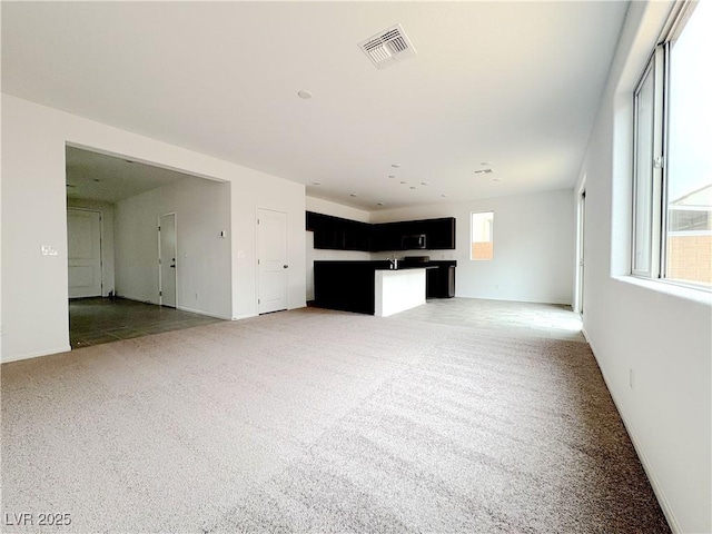 unfurnished living room with light carpet and visible vents