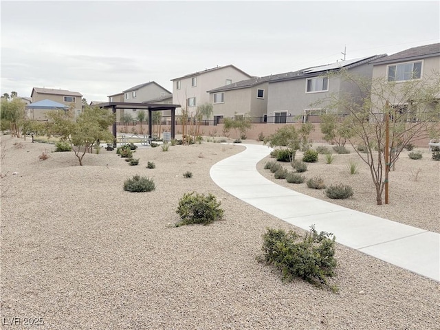 view of property's community with a residential view, fence, and a gazebo