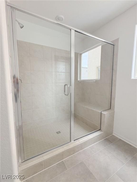 full bathroom with a stall shower and tile patterned flooring