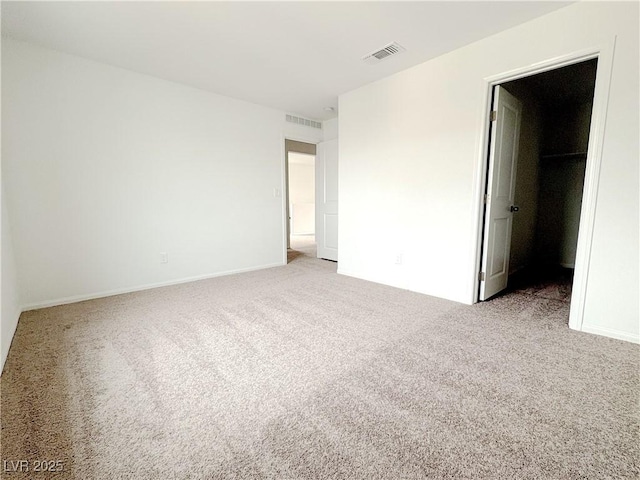 carpeted spare room with visible vents and baseboards