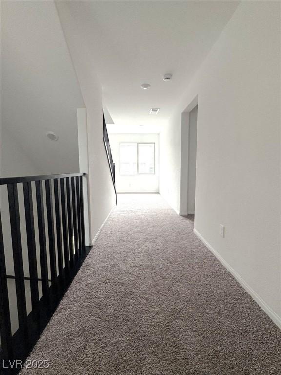 corridor with carpet floors and baseboards