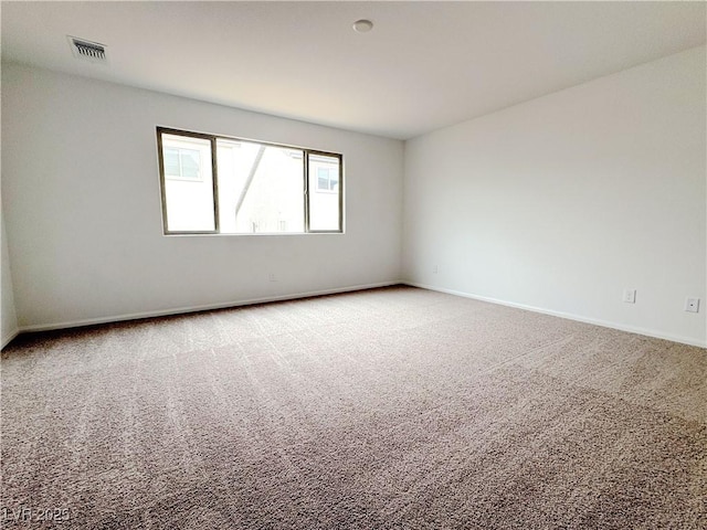 carpeted spare room featuring visible vents and baseboards