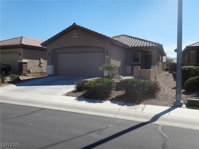 view of front facade featuring a garage, concrete driveway, a tile roof, and stucco siding