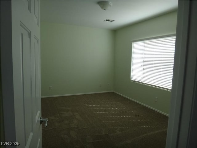 spare room featuring carpet flooring, visible vents, and baseboards