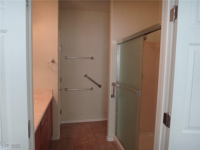 bathroom featuring a shower stall, vanity, baseboards, and tile patterned floors