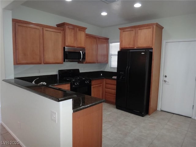 kitchen featuring dark stone counters, brown cabinetry, a peninsula, black appliances, and recessed lighting