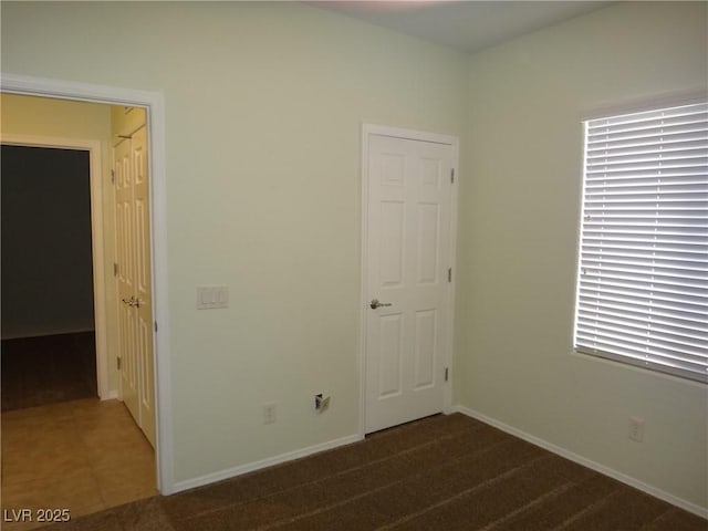 empty room featuring carpet flooring and baseboards