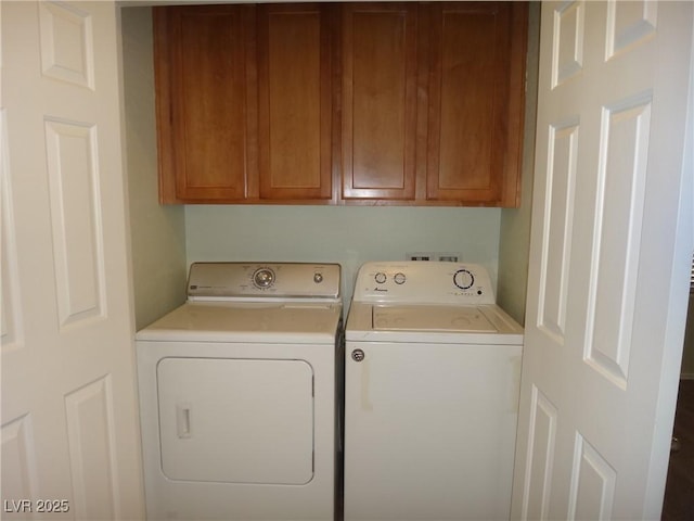 clothes washing area featuring independent washer and dryer and cabinet space