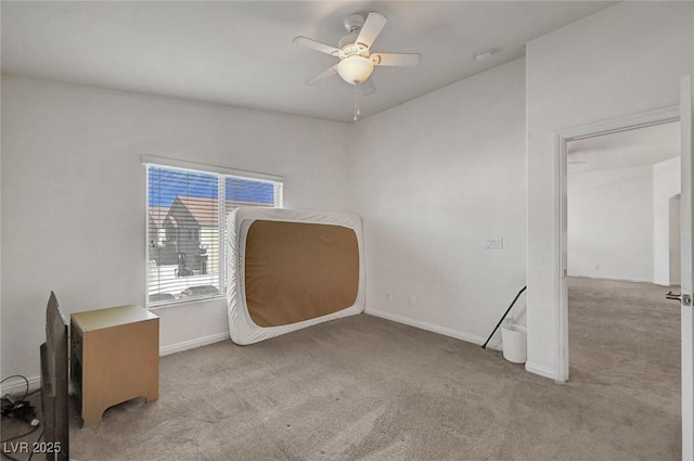 empty room featuring carpet, baseboards, and ceiling fan