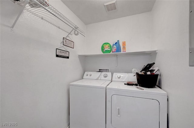 laundry area with laundry area, visible vents, and separate washer and dryer