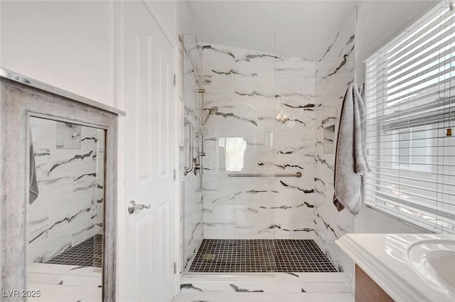 bathroom with a marble finish shower and vanity