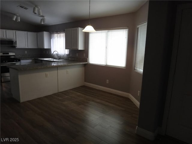 kitchen with a peninsula, dark wood-type flooring, a sink, visible vents, and stainless steel range with gas stovetop