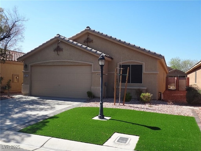 mediterranean / spanish-style house featuring driveway, stucco siding, a tiled roof, an attached garage, and a front yard