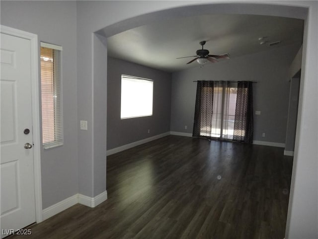 entrance foyer featuring baseboards, arched walkways, a ceiling fan, lofted ceiling, and dark wood-style floors