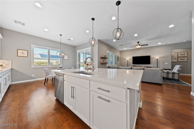 kitchen featuring dishwasher, visible vents, dark wood-style flooring, and a sink