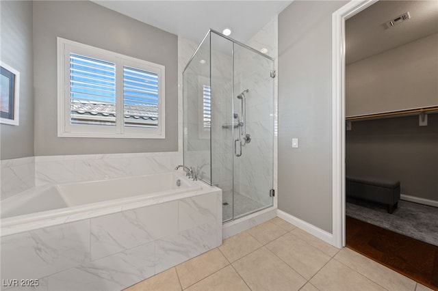 bathroom with a stall shower, visible vents, tile patterned floors, a spacious closet, and a bath